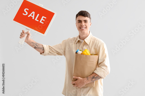 Young man with paper shoppi...