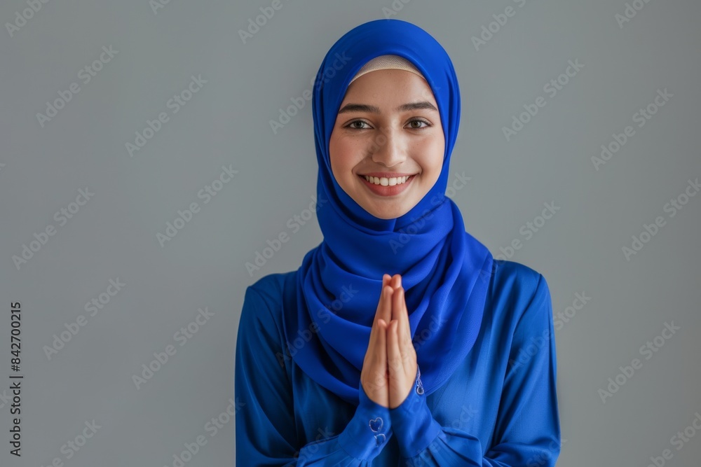 Angry Asian Muslim woman gesturing Eid Mubarak greetings over white background Angry Asian Muslim woman gesturing Eid Mubarak greetings over white background