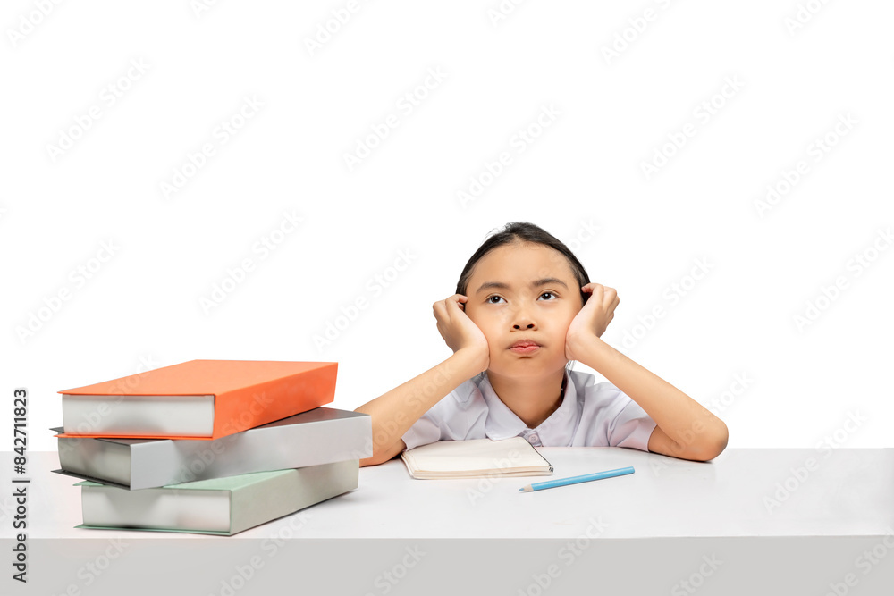 Portrait of an Asian elementary school student girl with a stack of books on the table tired of learning Portrait of an Asian elementary school student girl with a stack of books on the table tired of learning