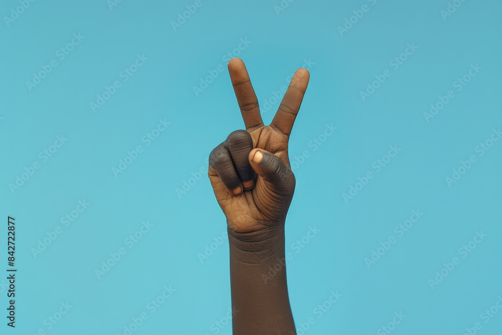 A black boy's hand reaches towards the sky, creating a peace sign A black boy's hand reaches towards the sky, creating a peace sign