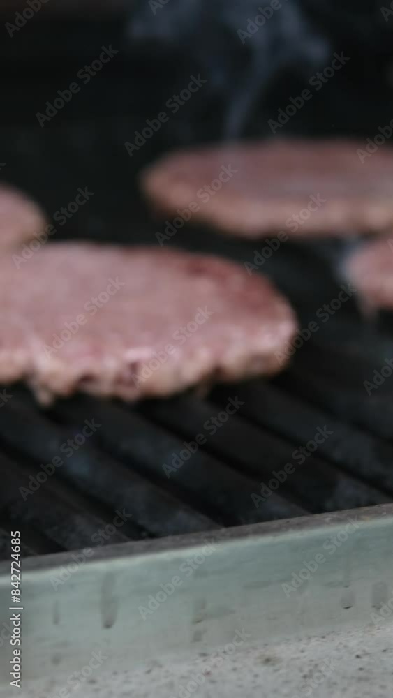 Cooking American fat smash burger on grill close-up. Beef or pork cutlet smashing by burger press. The chef in kitchen of the restaurant making cutlets for burgers - smash burger beefsteak. Fast and Cooking American fat smash burger on grill close-up. Beef or pork cutlet smashing by burger press. The chef in kitchen of the restaurant making cutlets for burgers - smash burger beefsteak. Fast and