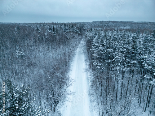 A snowy winter road running through the middle of the forest