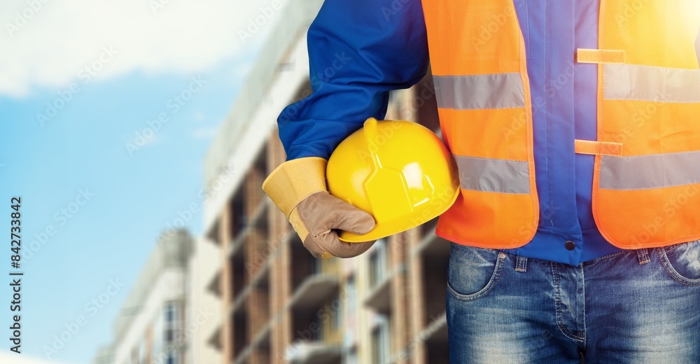 Construction worker with safety helmet at building site. Construction worker with safety helmet at building site.