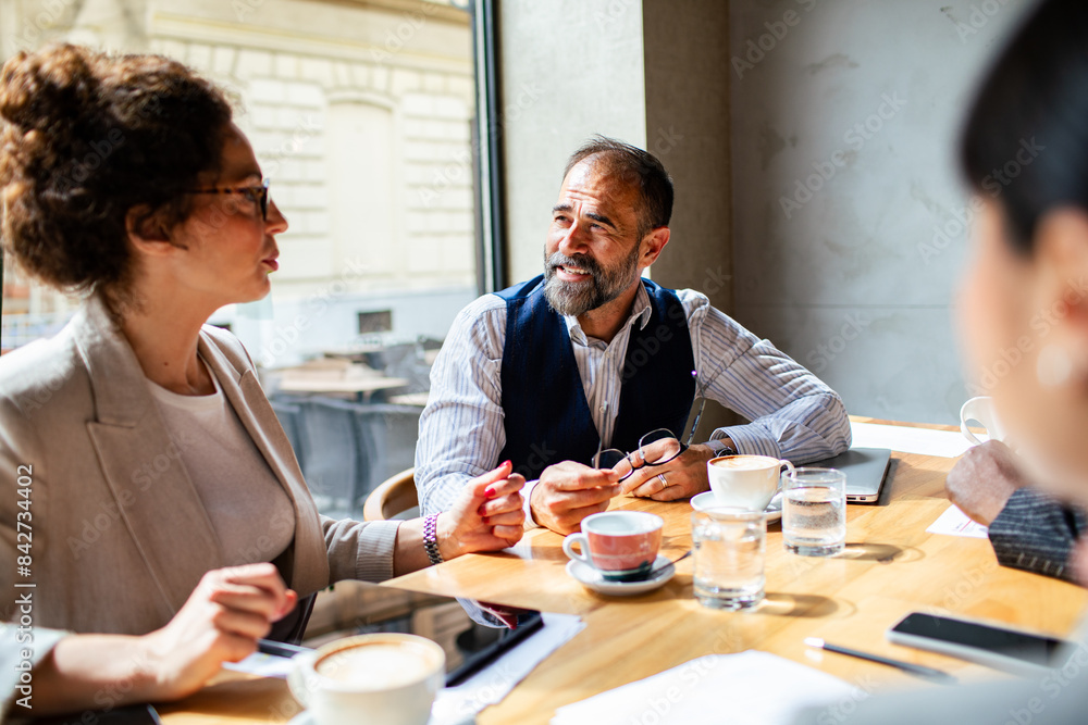 Business meeting in a cafe with diverse professionals Business meeting in a cafe with diverse professionals
