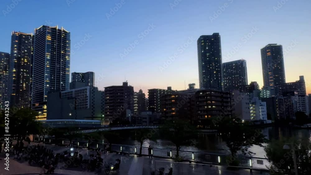 City skyline at sunset with modern buildings and a pedestrian walkway City skyline at sunset with modern buildings and a pedestrian walkway
