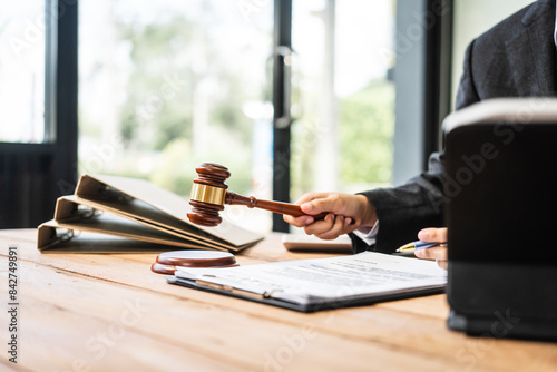 Fotografie A young businesswoman is working at her desk, diligently preparing legal briefs and reviewing evidence for an upcoming trial, demonstrating her expertise as a lawyer in litigation and advocacy