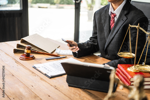 A young businesswoman is working at her desk, diligently preparing legal briefs and reviewing evidence for an upcoming trial, demonstrating her expertise as a lawyer in litigation and advocacy. photo