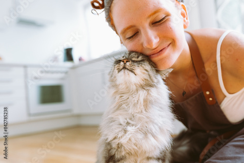 Portrait red-haired curly young woman with beloved fluffy domestic cat
