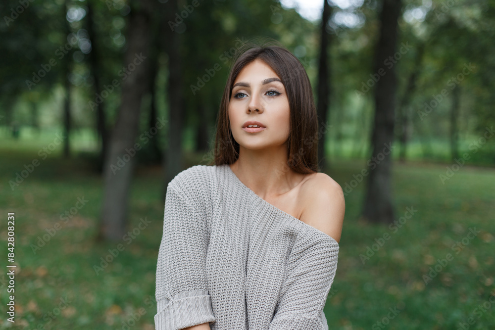 Beautiful natural fresh girl in a fashionable knitted sweater in a park in nature Beautiful natural fresh girl in a fashionable knitted sweater in a park in nature
