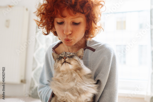 Canvas Print Portrait red-haired curly young woman with beloved fluffy domestic cat