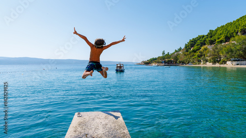 Happy boy jumping into the sea- Summer vacation, travel