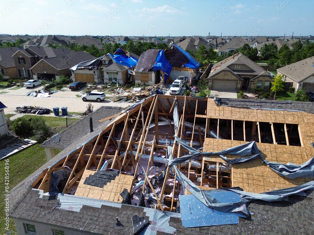 Poster Homes with severe damage to their roofs after a tornado moved ...