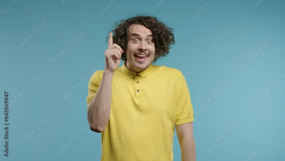 Brainy man having idea eureka moment, pointing finger up on blue.Solution,answer Brainy man having idea eureka moment, pointing finger up on blue.Solution,answer