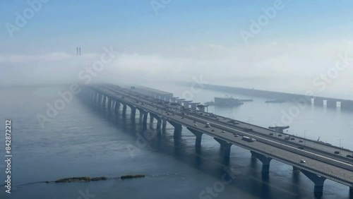 Fog rapidly receding over a long bridge