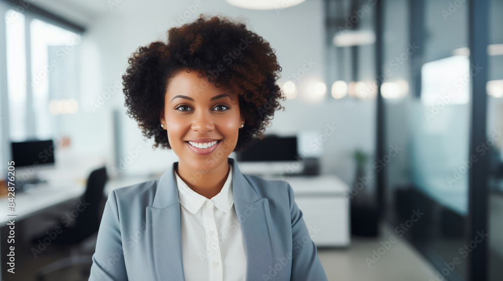 Portrait confident happy smiling african businesswoman standing in the office looking at camera Portrait confident happy smiling african businesswoman standing in the office looking at camera