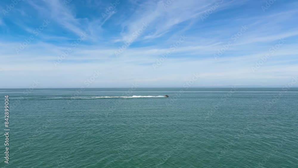 Tourist rides a jet ski. Outdoor activity, vacation on the sea. Distant jetski passing on the beautiful seascape of the Black Sea at summer sunny day Tourist rides a jet ski. Outdoor activity, vacation on the sea. Distant jetski passing on the beautiful seascape of the Black Sea at summer sunny day