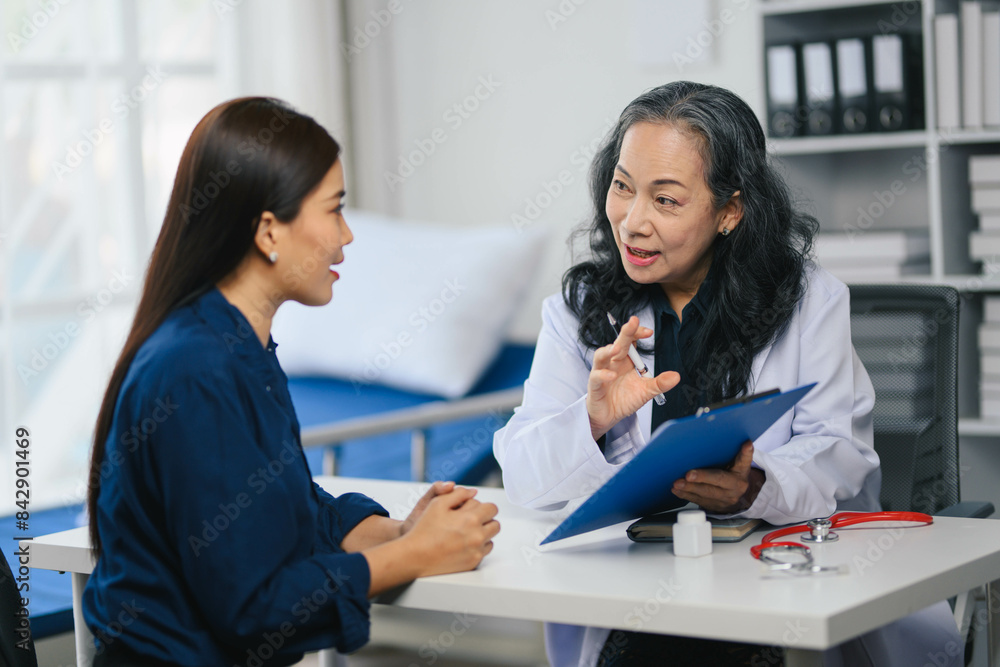 A woman is sitting at a desk with a doctor A woman is sitting at a desk with a doctor