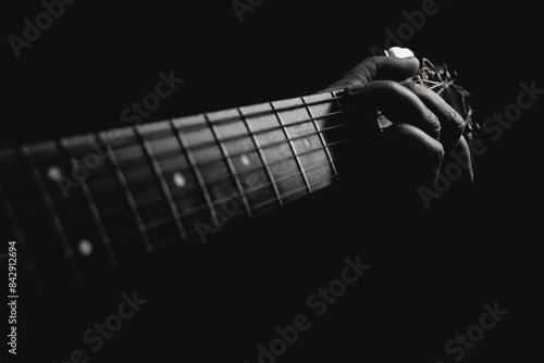 Guitarist pressing chords under lamp light