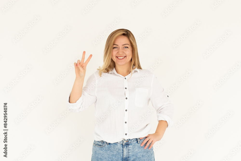 Young european woman wearing white shirt smiling looking to the camera showing fingers doing victory sign. number two.