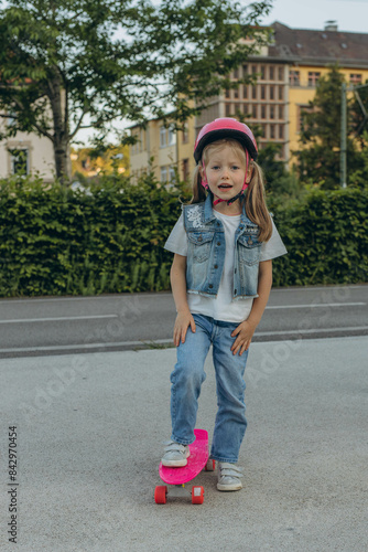 Cute little girl stands with a skateboard