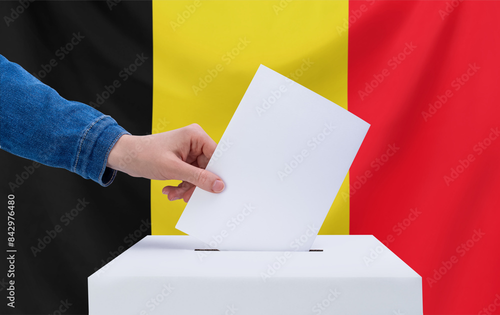 Elections, Belgium. Election concept. The voter throws the ballot into the box. Elections, Belgium. Election concept. The voter throws the ballot into the box.