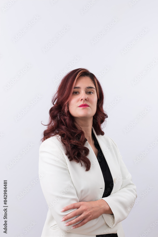 Portrait of confident red-haired business woman looking at camera with jacket suit and crossed arms. White background and copy space. Concept of business, woman and entrepreneurship Portrait of confident red-haired business woman looking at camera with jacket suit and crossed arms. White background and copy space. Concept of business, woman and entrepreneurship