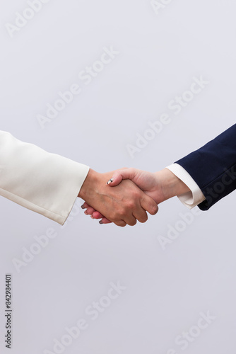 Hands of 2 business women shaking hands closing a deal. Isolated on white background with copy space. Concept of business, deal, partnership and business women