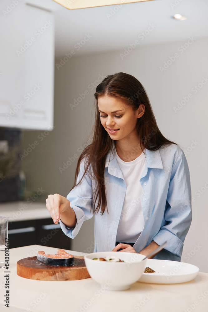 Woman in white shirt preparing food on cutting board in kitchen Cooking homemade meal in modern culinary environment Woman in white shirt preparing food on cutting board in kitchen Cooking homemade meal in modern culinary environment