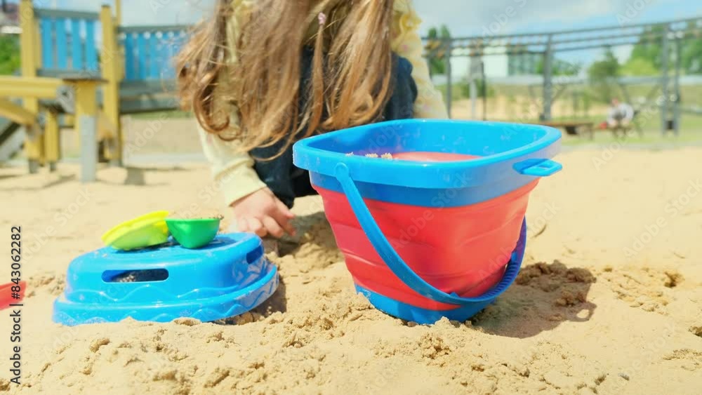 baby in the sandbox close-up. happy family kid dream concept. a little girl in the sand and plays with her colorful toys. little girl playing lifestyle outdoors baby in the sandbox close-up. happy family kid dream concept. a little girl in the sand and plays with her colorful toys. little girl playing lifestyle outdoors