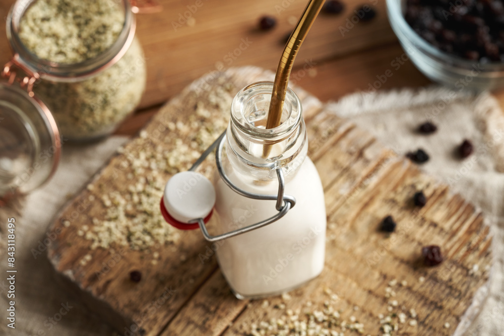 Vegan hemp seed milk in a glass bottle with an ecological stainless steel straw