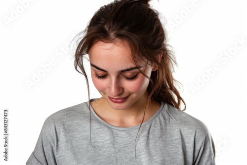 A young woman examining her cell phone with a thoughtful expression