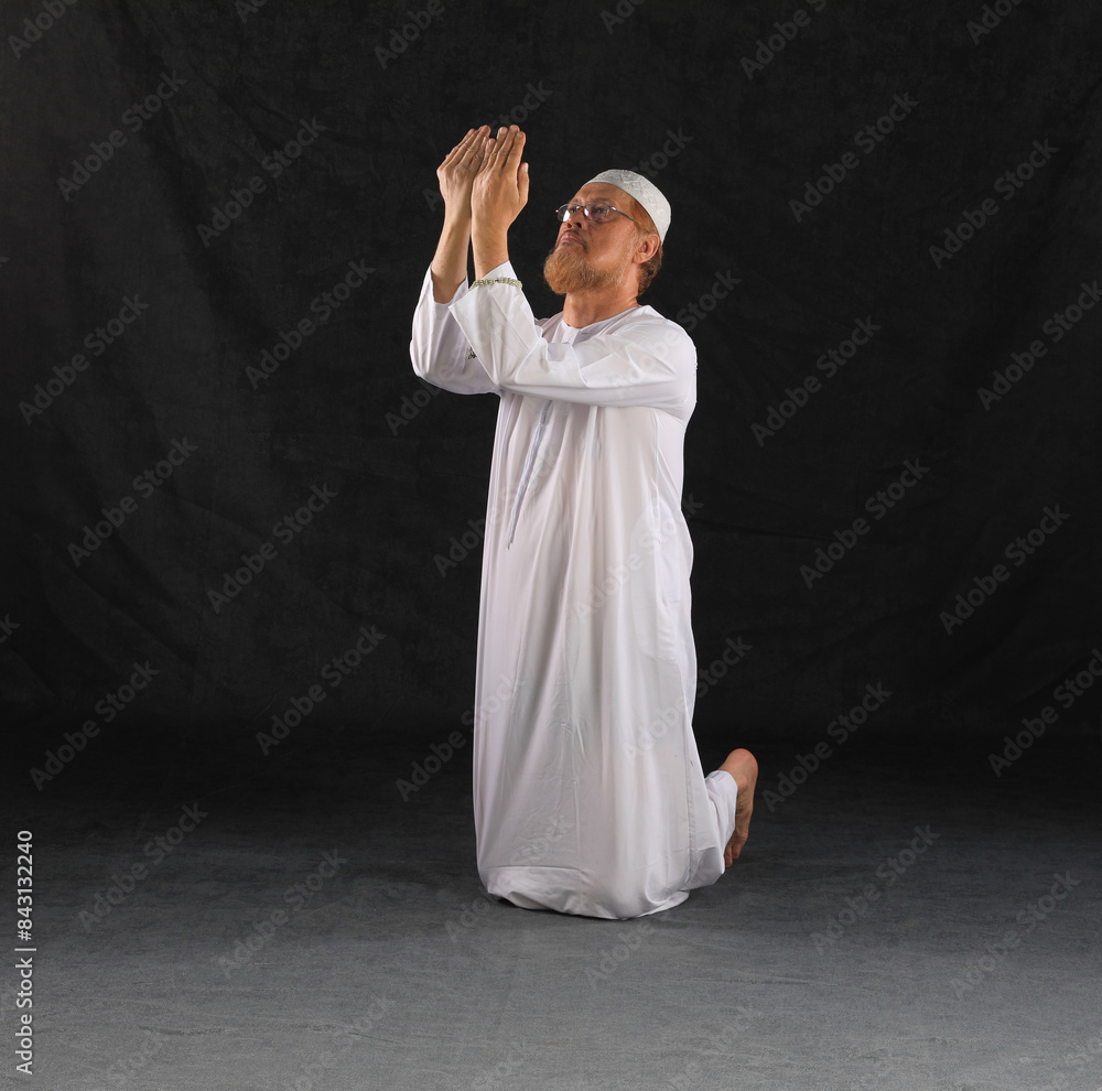 Muslim Arab man in white clothes praying Muslim Arab man in white clothes praying