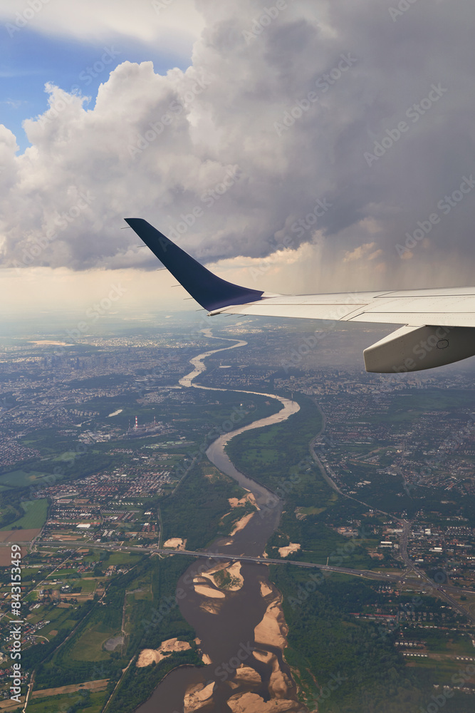 Plane flying over the city of Warsaw, Poland with visible Vistula river