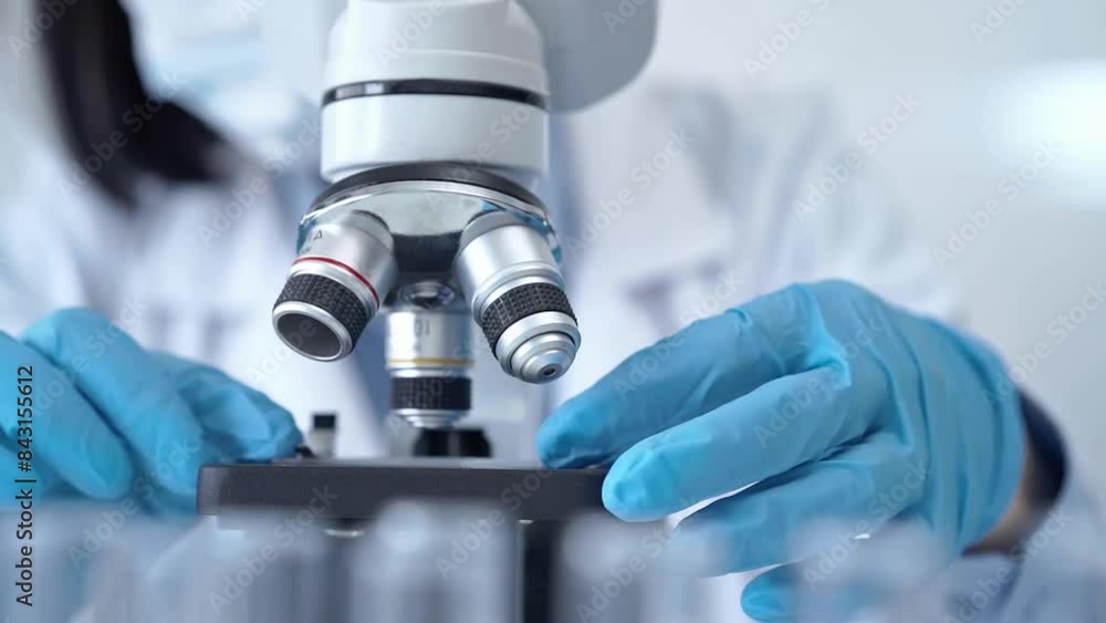 Scientist using microscope in laboratory Scientist using microscope in laboratory