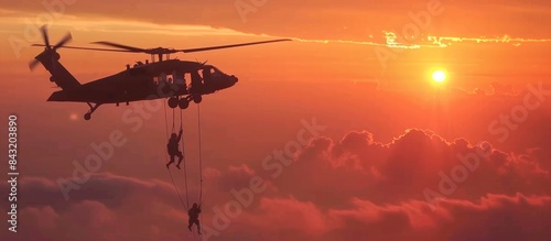 A group of soldiers are parachuting out of a helicopter photo