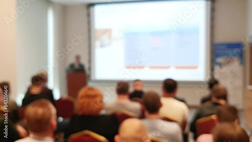 Blurred defocused footage with back view of audience in a business conference or seminar. Audience listens to the lecturer at the conference in auditorium. photo
