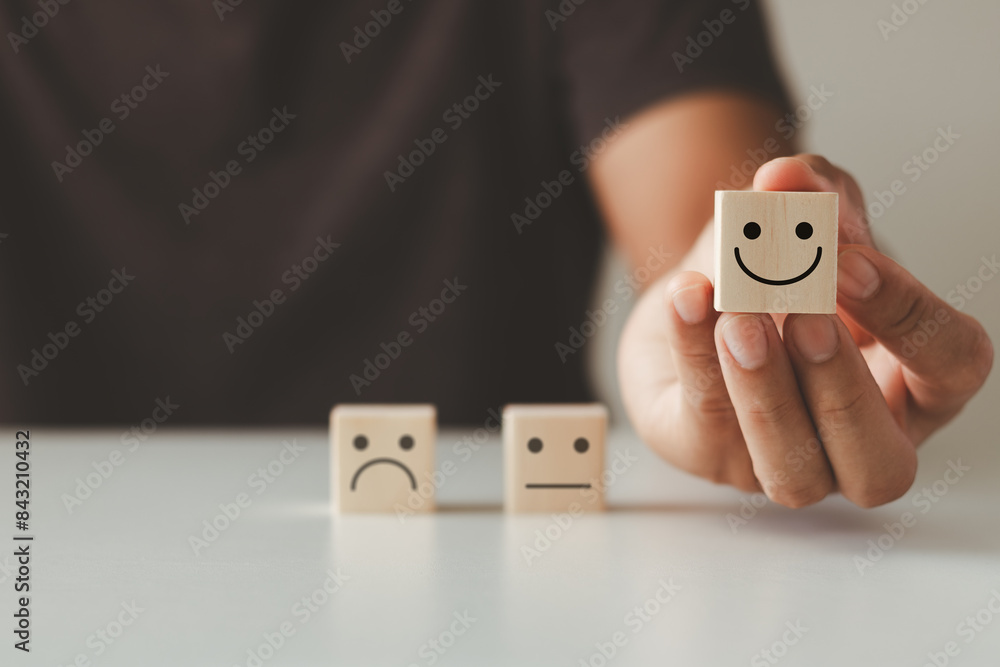 © THAWEERAT - Customer satisfaction concept. Hand of a businessman chooses a smiling face on a wooden cube block. Customer services best excellent business rating experience. © THAWEERAT - Customer satisfaction concept. Hand of a businessman chooses a smiling face on a wooden cube block. Customer services best excellent business rating experience.
