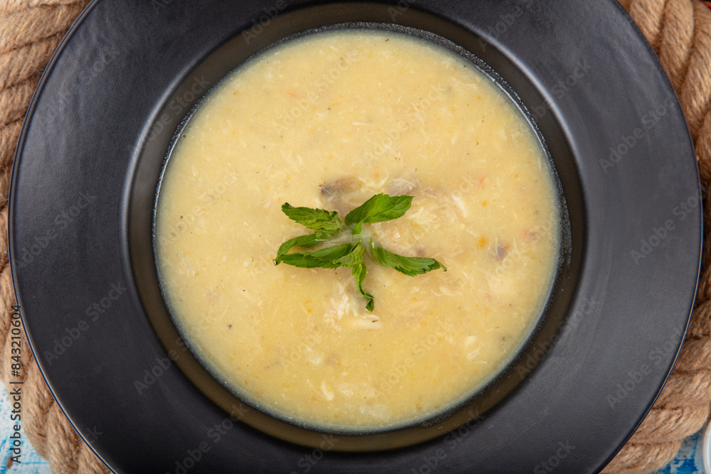 Fish soup in a bowl. Fish soup with cream, sauces, lemon, herbs and croutons on wooden background. Fish soup in a bowl. Fish soup with cream, sauces, lemon, herbs and croutons on wooden background.