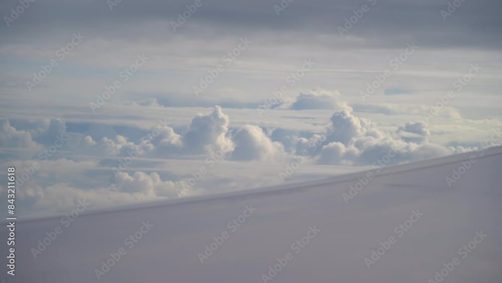 Looking through window aircraft during flight in wing. Airplane flight. Wing of an airplane flying above the clouds. View from the window of the plane. Aircraft. Traveling. Looking through window aircraft during flight in wing. Airplane flight. Wing of an airplane flying above the clouds. View from the window of the plane. Aircraft. Traveling.
