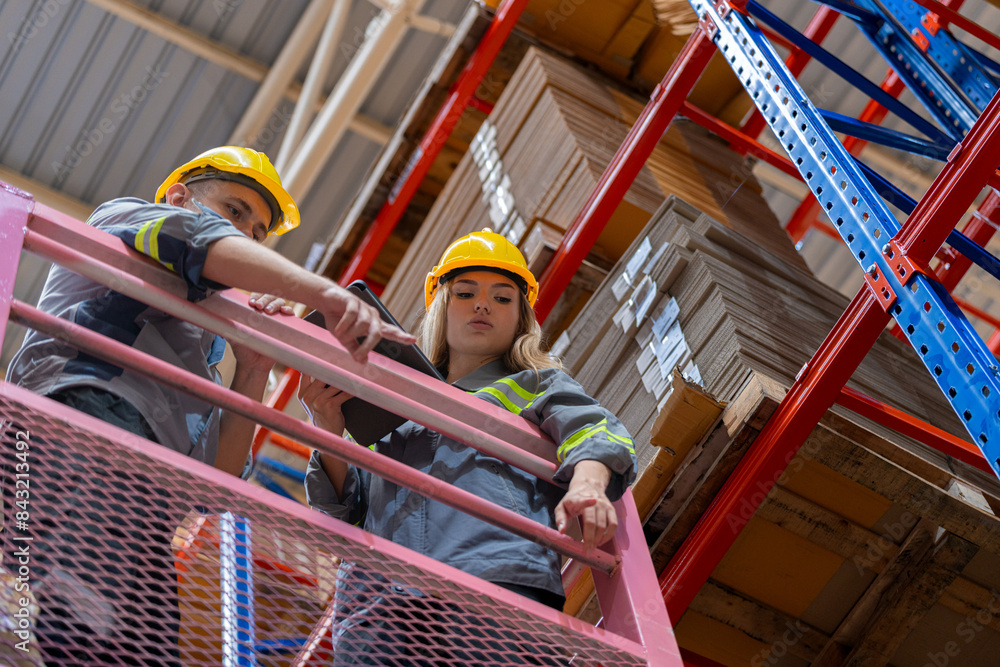 workers man and woman using a hydraulic scissor lift to check stock near the shelves warehouse. industry factory warehouse. Worker Screening Package In Warehouse. workers man and woman using a hydraulic scissor lift to check stock near the shelves warehouse. industry factory warehouse. Worker Screening Package In Warehouse.