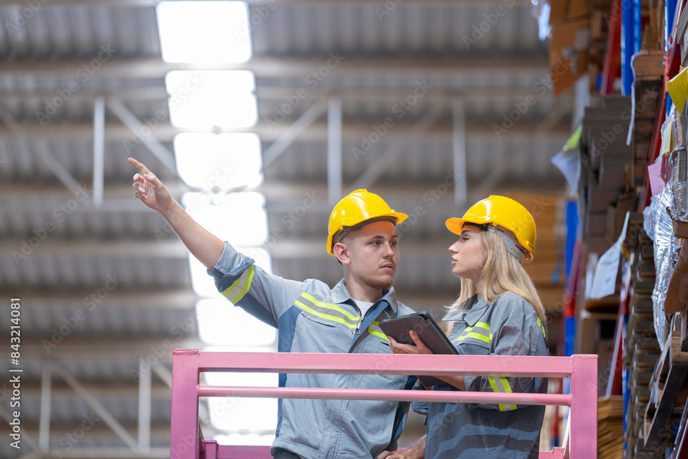 workers man and woman using a hydraulic scissor lift to check stock near the shelves warehouse. industry factory warehouse. Worker Screening Package In Warehouse. workers man and woman using a hydraulic scissor lift to check stock near the shelves warehouse. industry factory warehouse. Worker Screening Package In Warehouse.