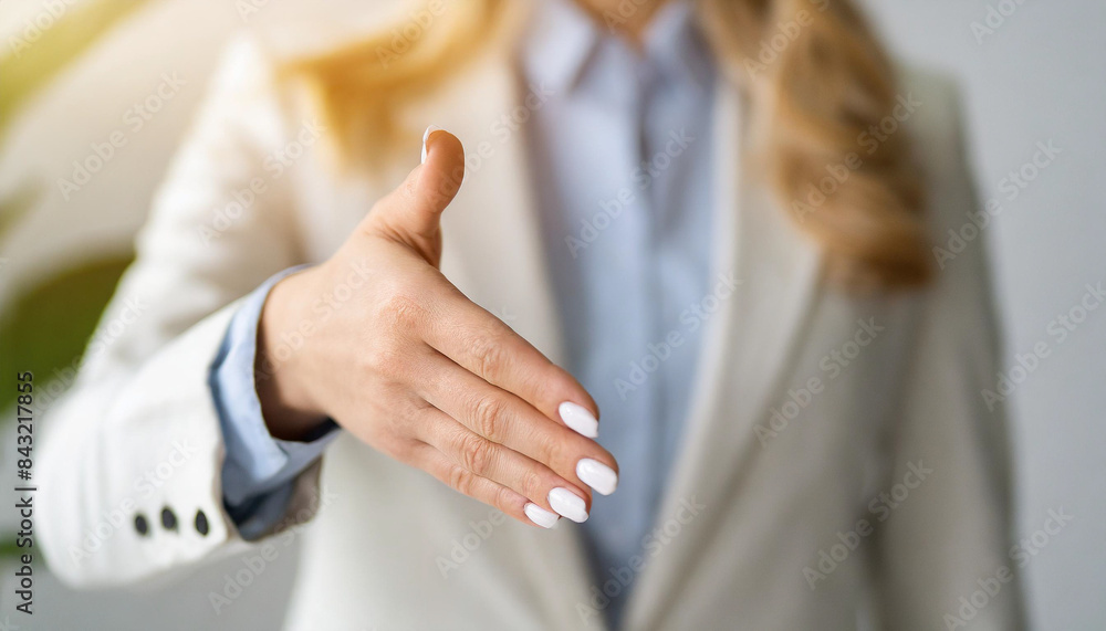 businesswoman's handshake in white suit, symbolizing agreement and trust in bright corporate setting businesswoman's handshake in white suit, symbolizing agreement and trust in bright corporate setting
