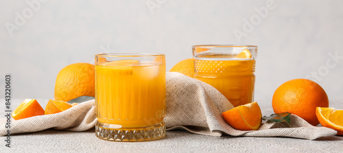 Foto Glasses of tasty orange juice on light background