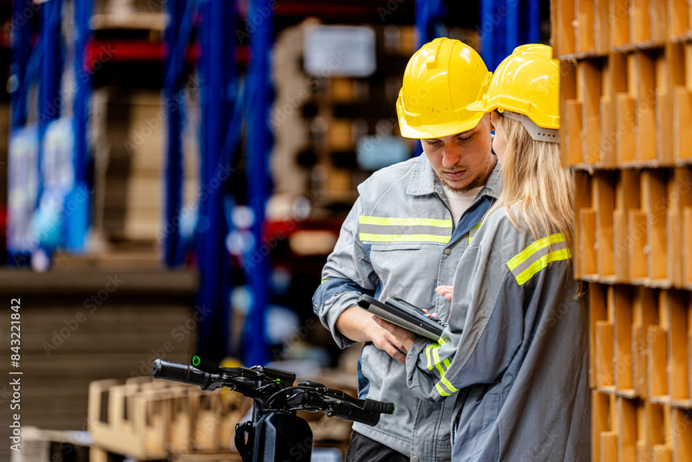 A team of engineers inspected the warehouse, with men and women standing and talking with documents in their hands. A team of engineers inspected the warehouse, with men and women standing and talking with documents in their hands.