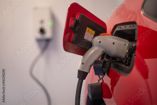 Electric red car being charged
