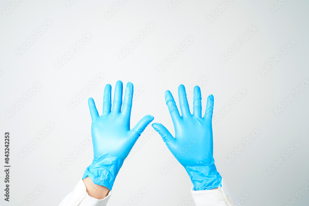 Obraz premium Doctor's hand in blue medical gloves holding an object on a white background
