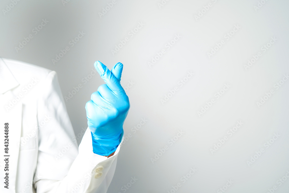 Human rising hands make finger heart shape wearing blue surgical glove, isolated Human rising hands make finger heart shape wearing blue surgical glove, isolated