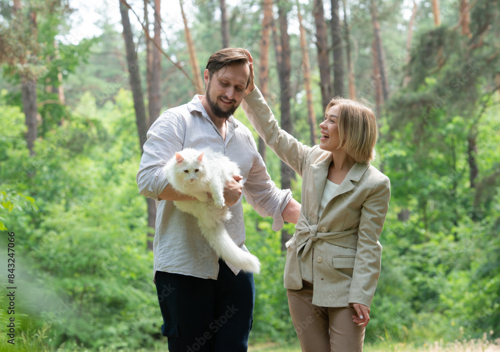 Fototapeta premium couple spending time together outdoors with a cat