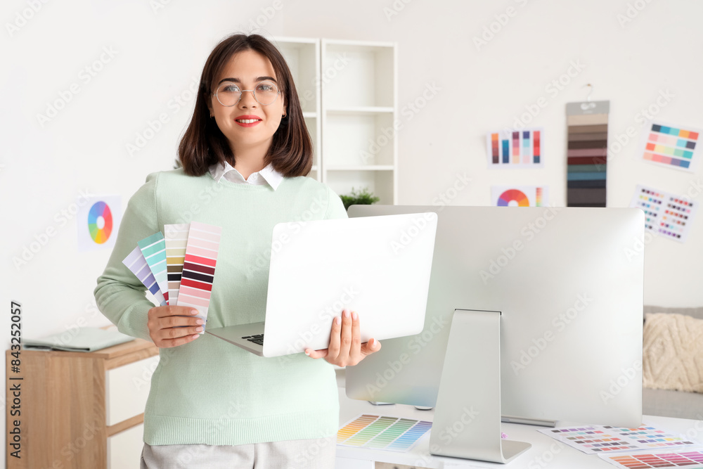 © Pixel-Shot - Beautiful interior designer with laptop and color palettes in office