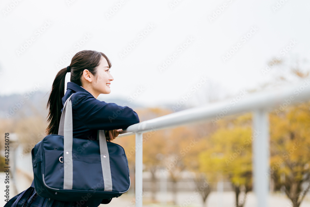 Obraz premium 下校・通学・登校中に待ち合わせ・景色を眺める制服姿の女子高校生・女子高生・女子中学生